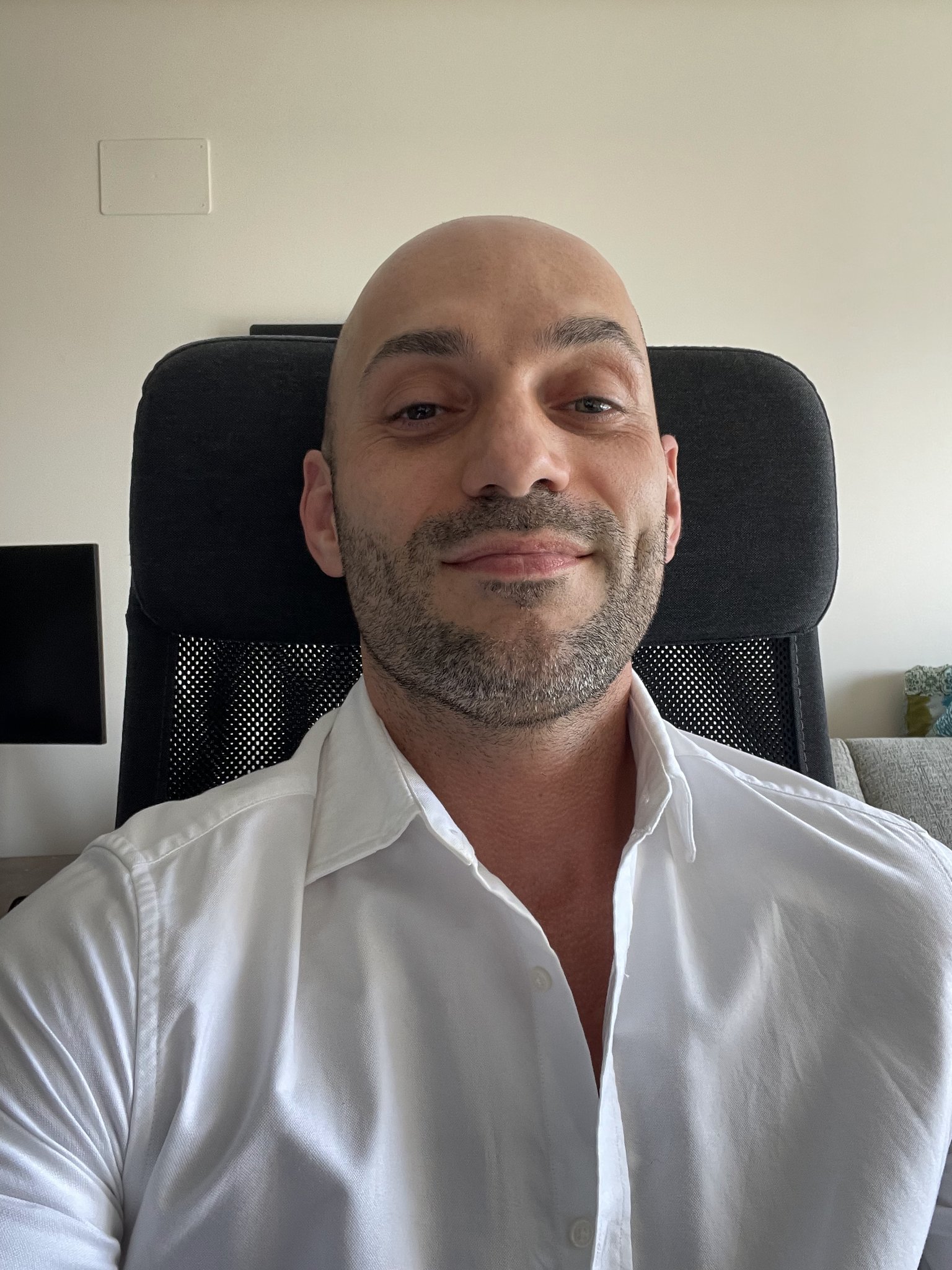 Portrait of a woman with brown hair on a flat gray background.