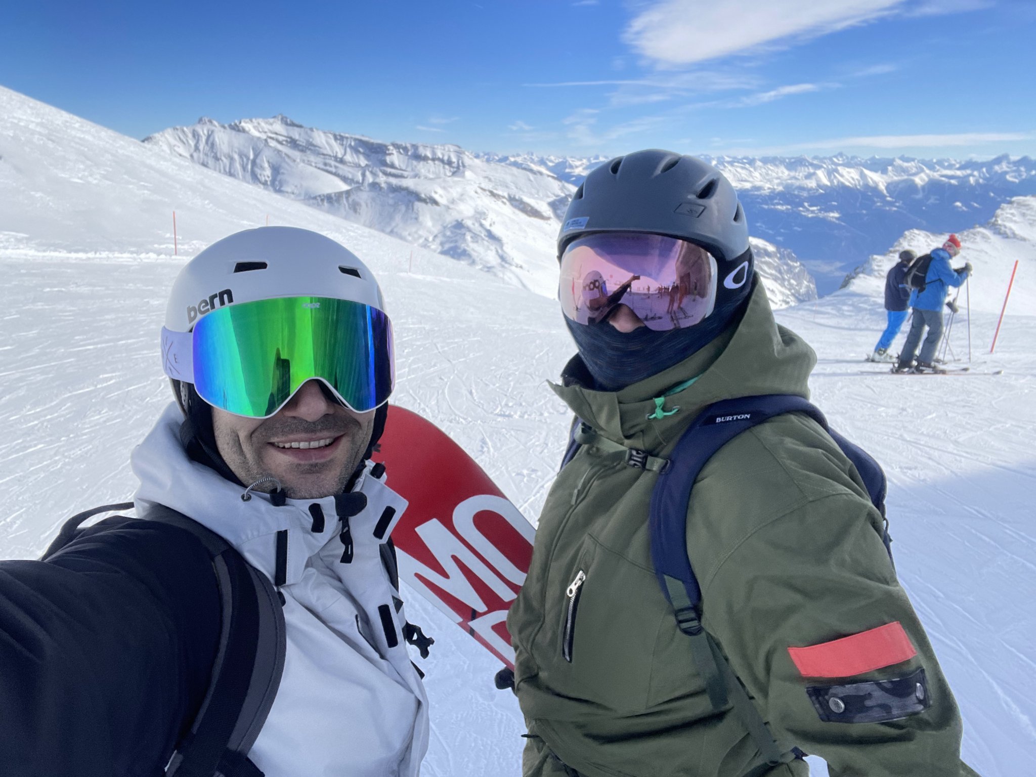 Portrait of a man with brown hair and glasses on a flat gray background.